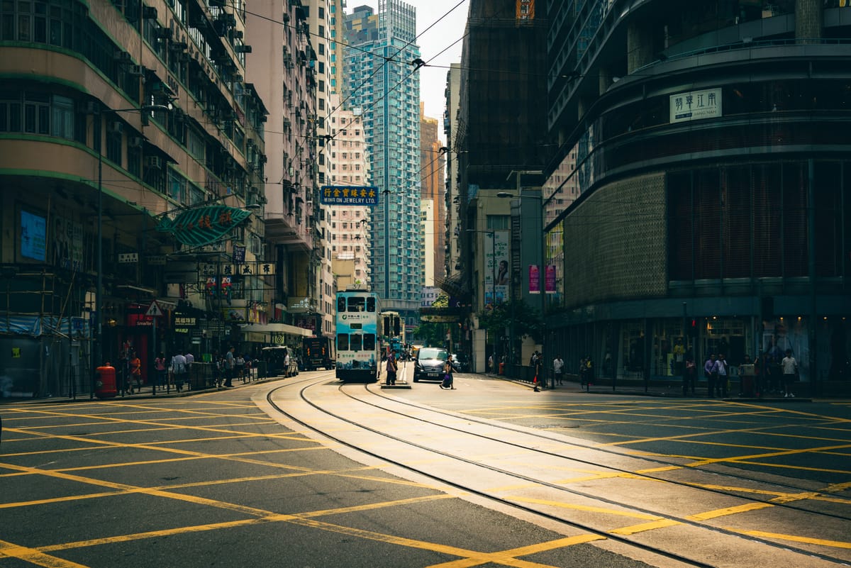 Escena callejera de la isla de Hong Kong con los icónicos tranvías de dos pisos sobre las vías