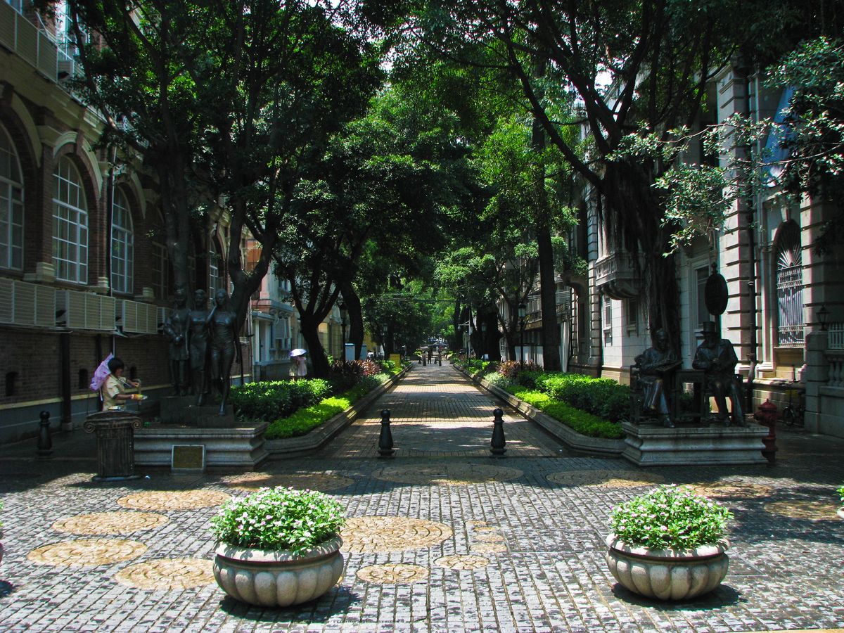 Una mansion colonial en tonos pastel en una calle arbolada de la isla de Shamian