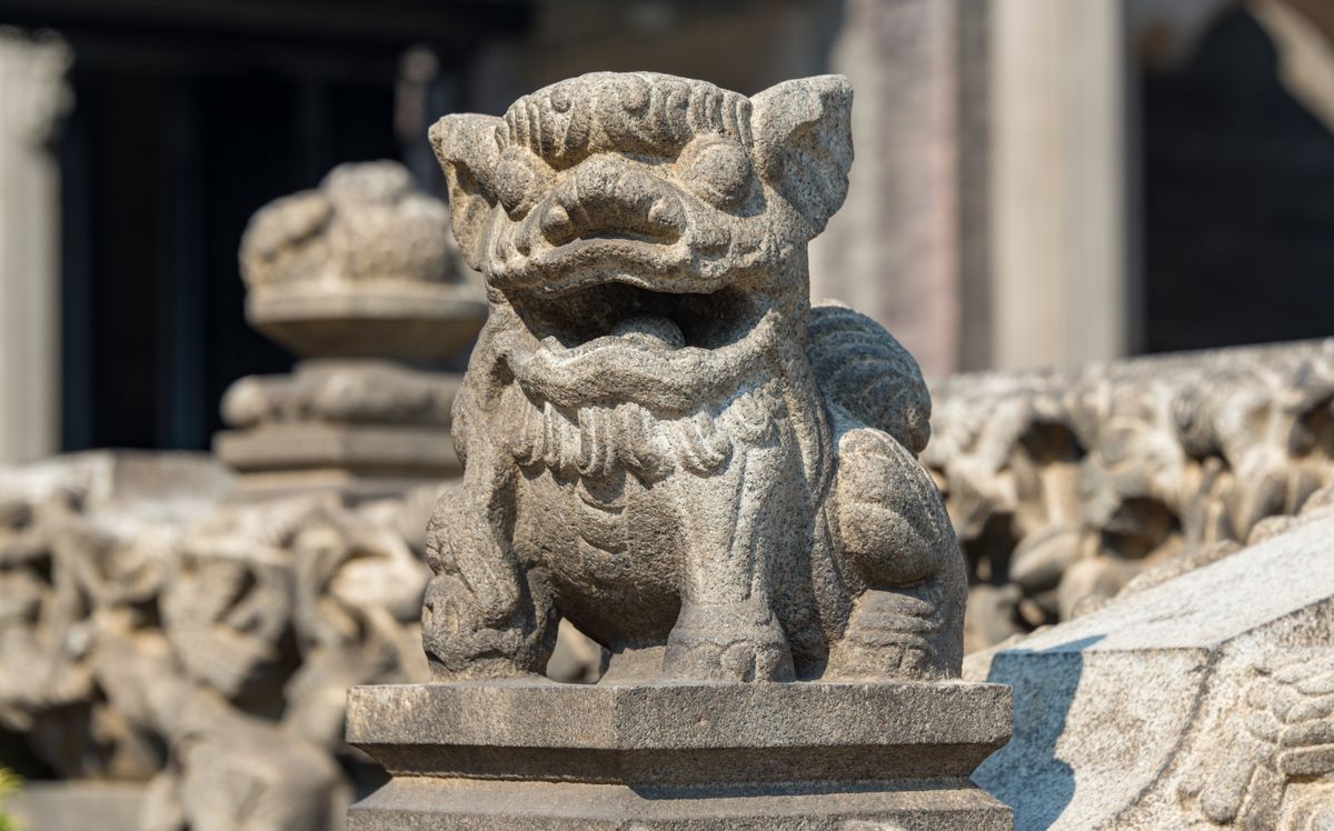 Un león guardián de piedra tallada en el Templo del Clan Chen