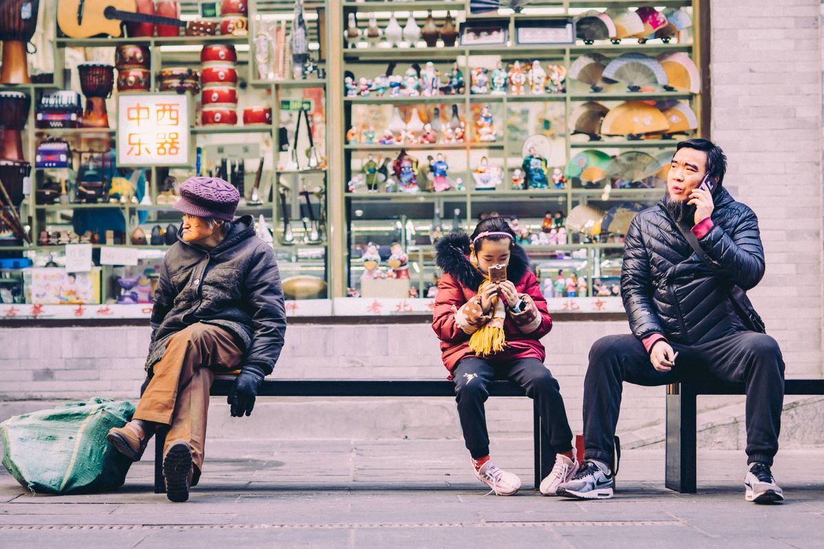 Personas mirando sus teléfonos en una calle de China
