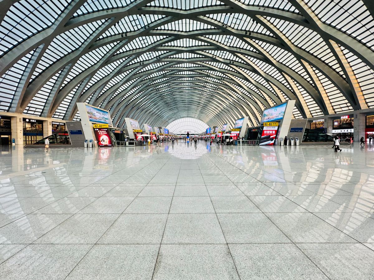 Amplio vestibulo de una moderna estacion de tren china con un techo de cristal en arco
