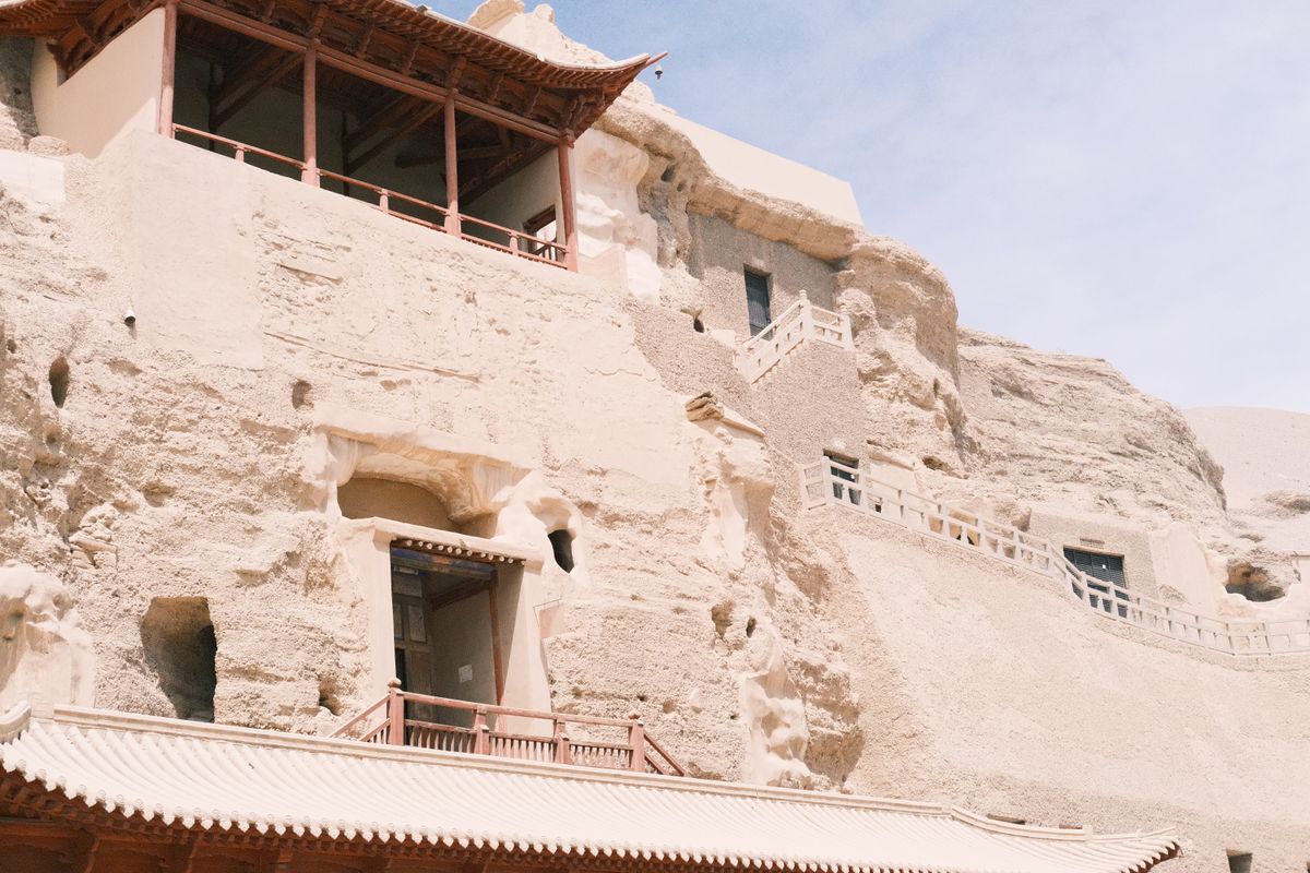 The cliff face and ornate entrances of the Mogao Caves Buddhist grottoes in Dunhuang