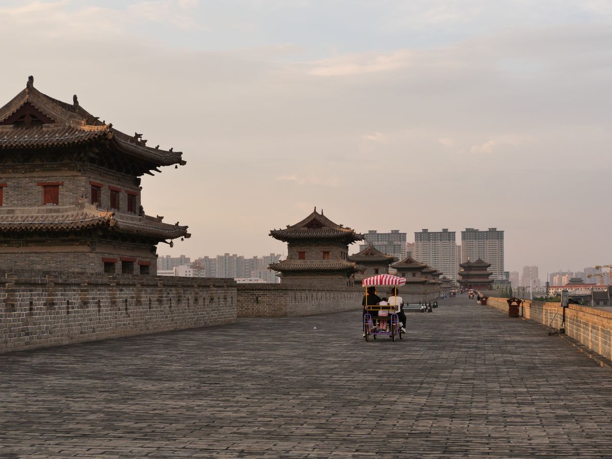 Visitantes pedaleando por la ancha superficie de ladrillo de la Muralla de Xi'an