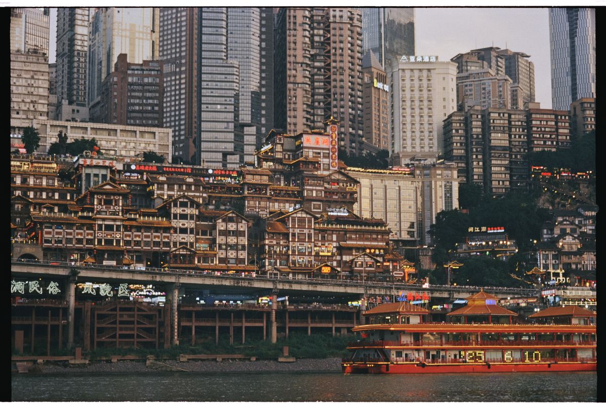 Edificios sobre pilotes junto al río y paisaje nocturno de Chongqing