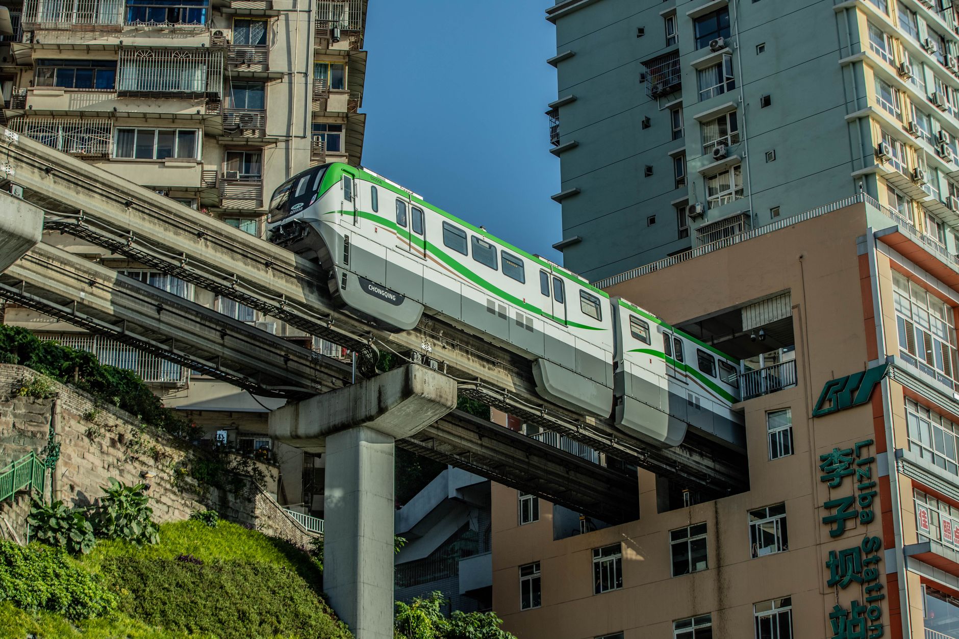 Tren del monorraíl saliendo de la torre residencial en Liziba