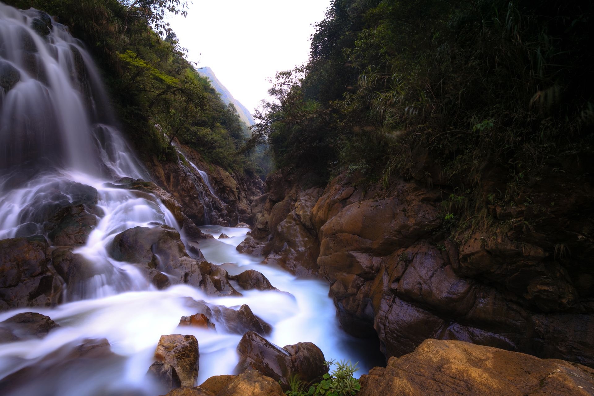 Cascada cayendo sobre las rocas en una poza clara del Valle Esmeralda