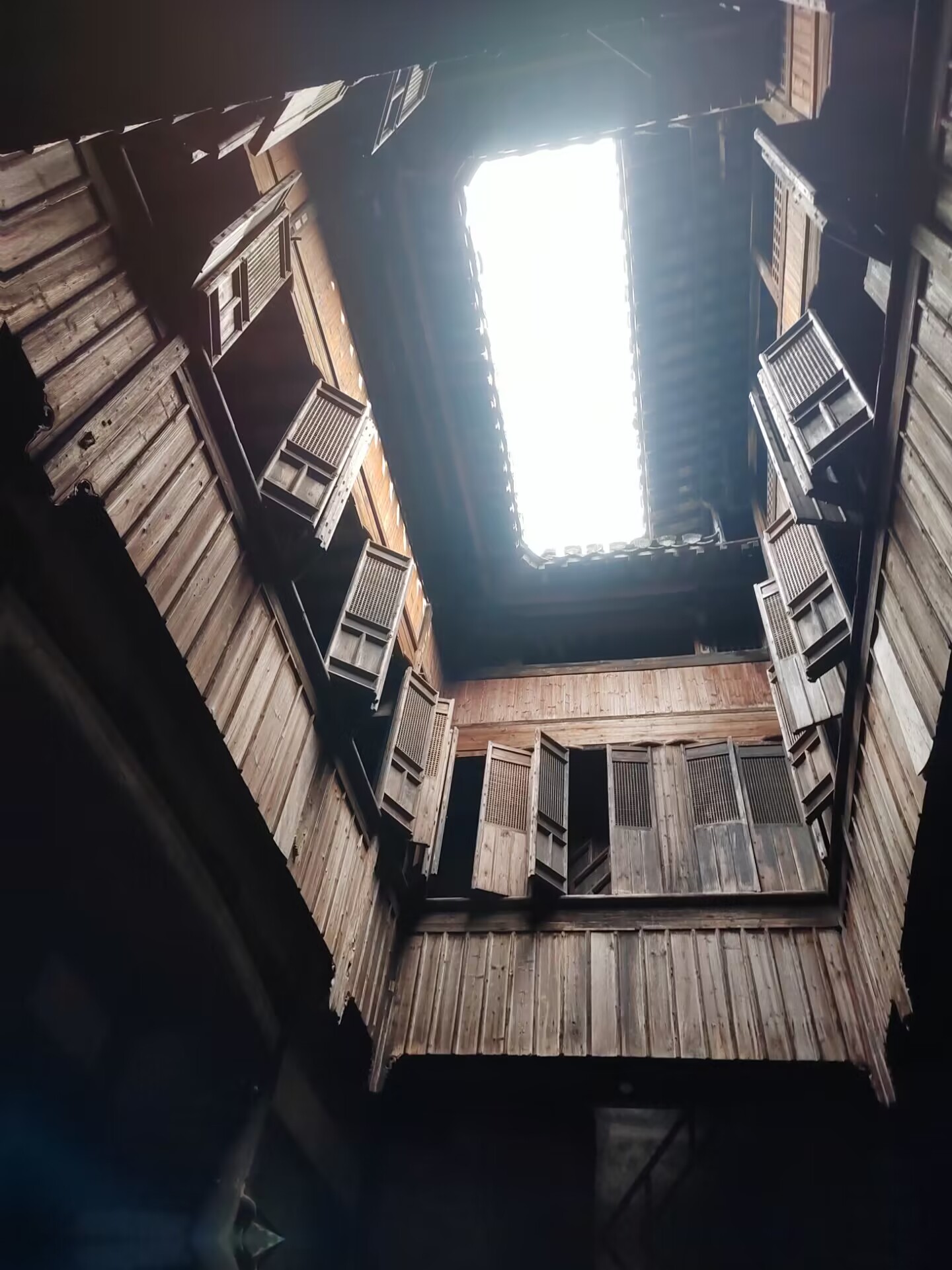 Mirando hacia arriba un patio de pozo de luz de madera en una casa de Chengkan
