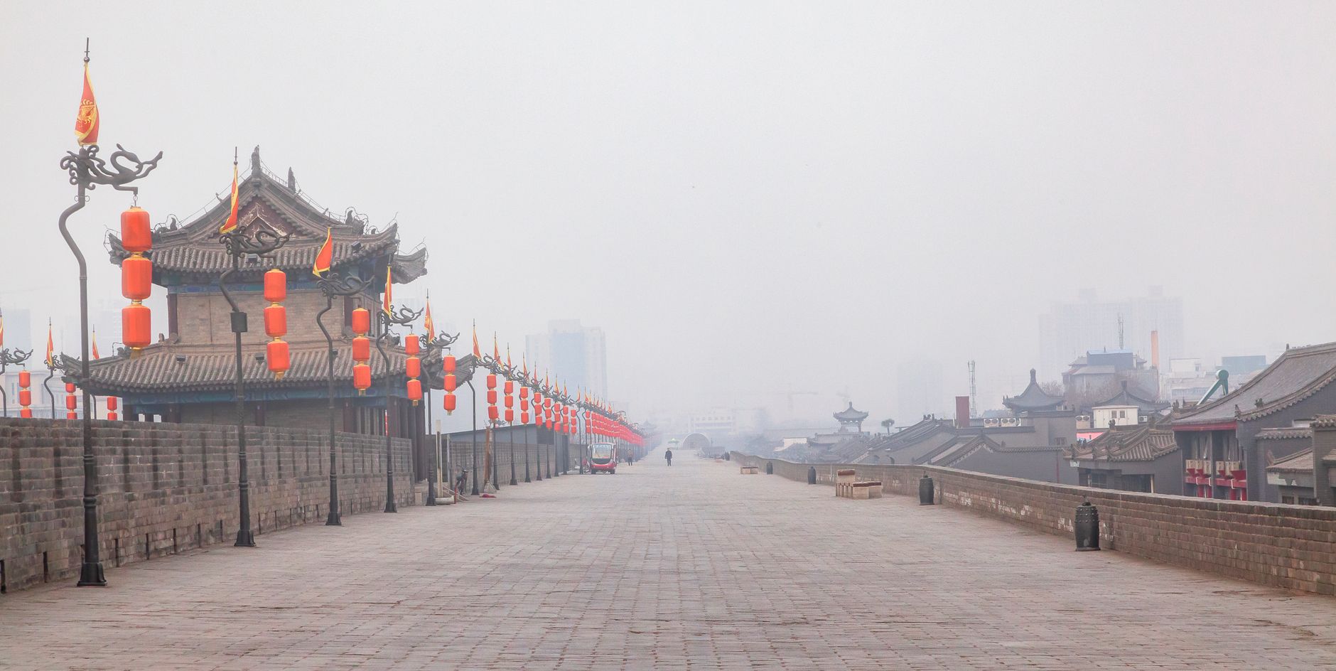 Ciclistas y faroles rojos sobre la amplia Muralla de Xi'an