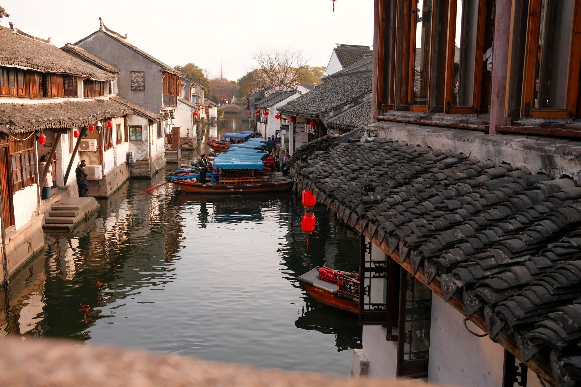 Lantern-lit canal lined with old houses and boats in Suzhou's water town