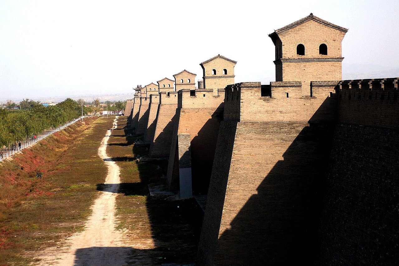 El baluarte de ladrillo gris de Pingyao con una hilera de torres de vigilancia sobre el foso seco