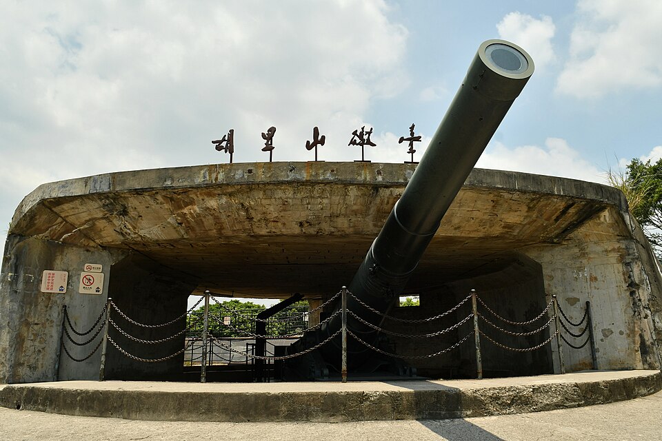 The giant Krupp cannon at Hulishan Fortress, under the fort's name plaque