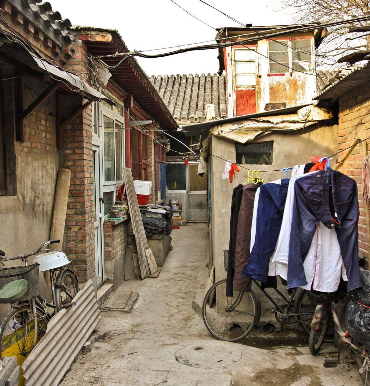 Una tranquila callejuela residencial de Nanluoguxiang con bicicletas y ropa tendida