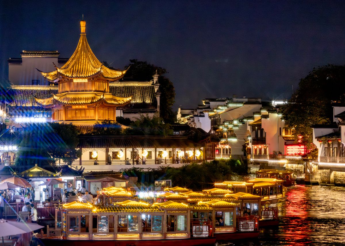 Arquitectura tradicional iluminada reflejada en el río Qinhuai