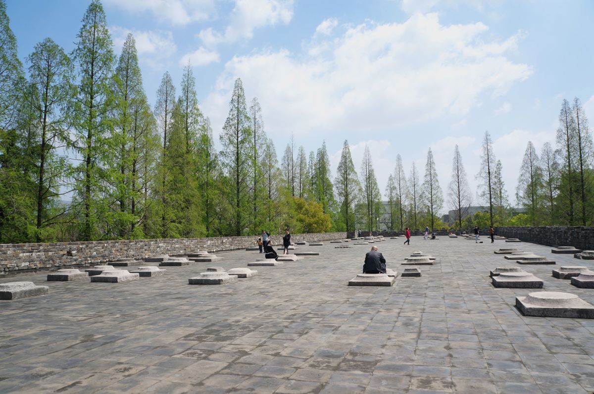 Antigua muralla gris y explanada de piedra bajo un cielo azul