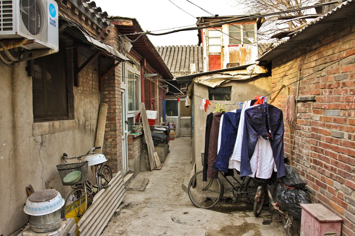 Narrow hutong alley in Beijing's old town with courtyard housing and bicycles