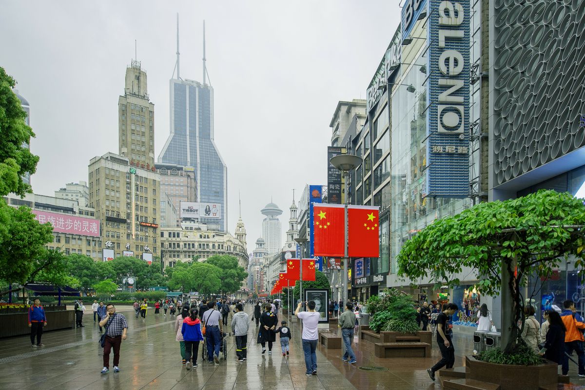 A pedestrian shopping street near Nanjing Road in Shanghai with crowds and storefronts