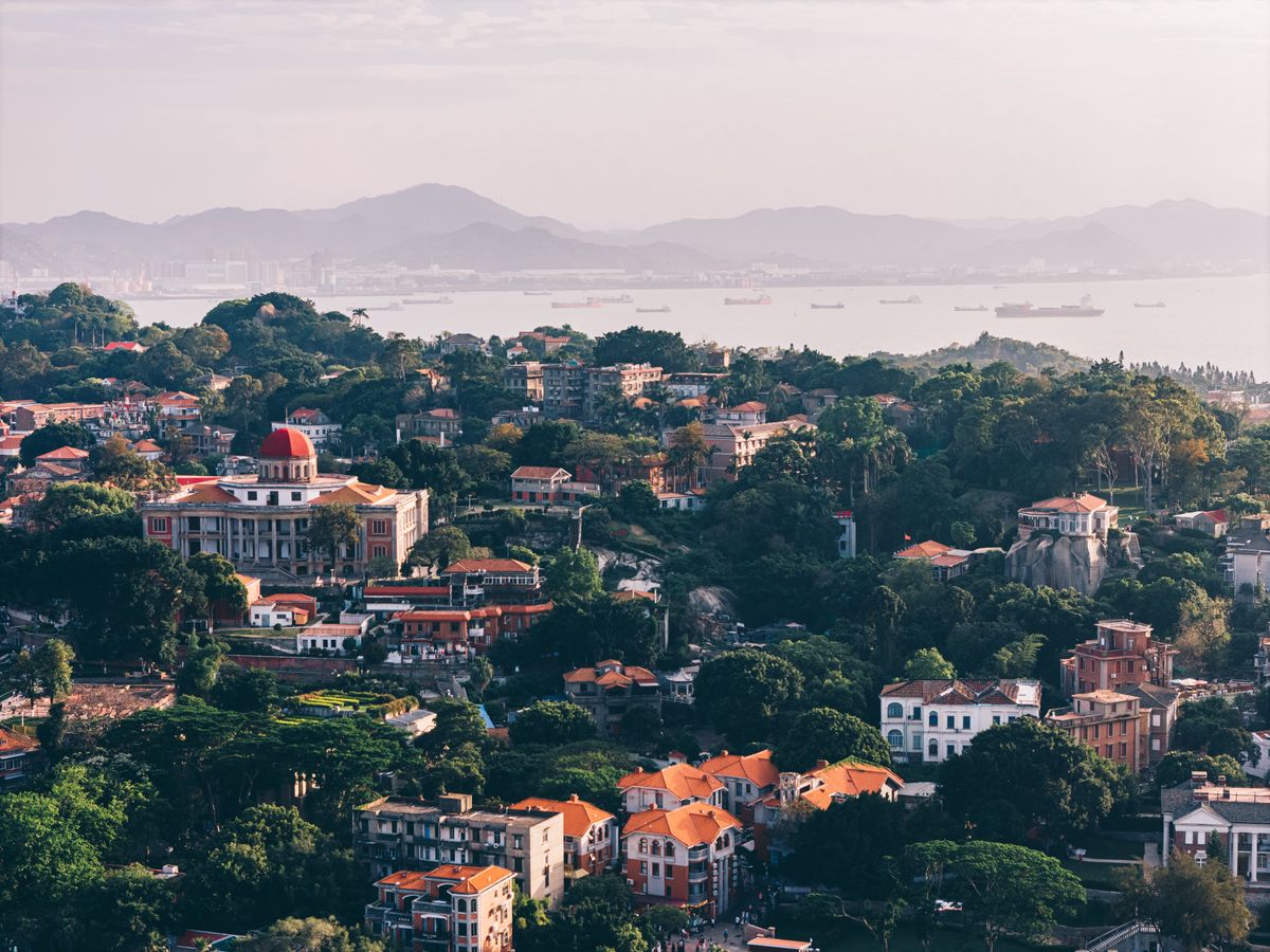 Aerial view of Gulangyu Island's red-roofed colonial architecture and harbor in Xiamen