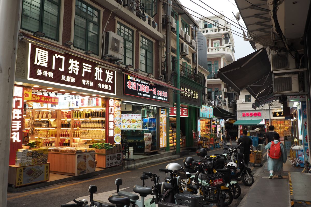 Street-level shops and scooters on a downtown Xiamen shopping street