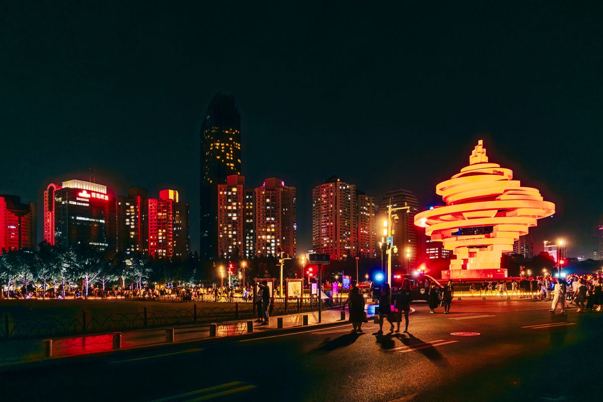 May Fourth Square's red "Wind of May" sculpture lit up at night in Qingdao's CBD