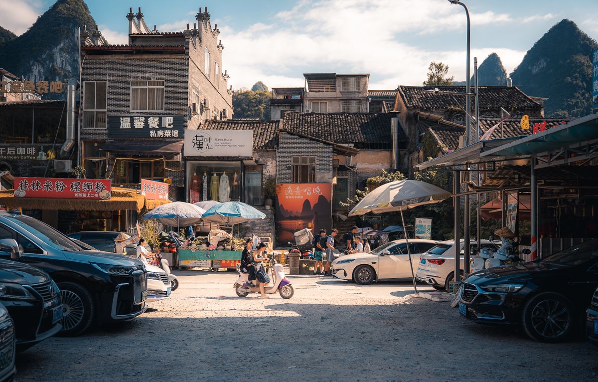 A traditional shopping street in Yangshuo County, Guangxi, lined with small shops and cars