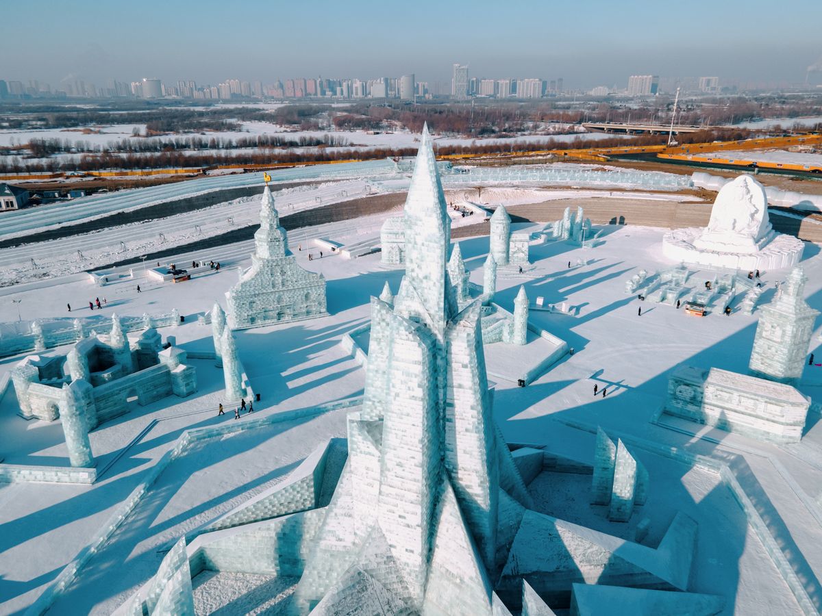 Ice sculptures glowing at Harbin's Ice and Snow Festival at dusk