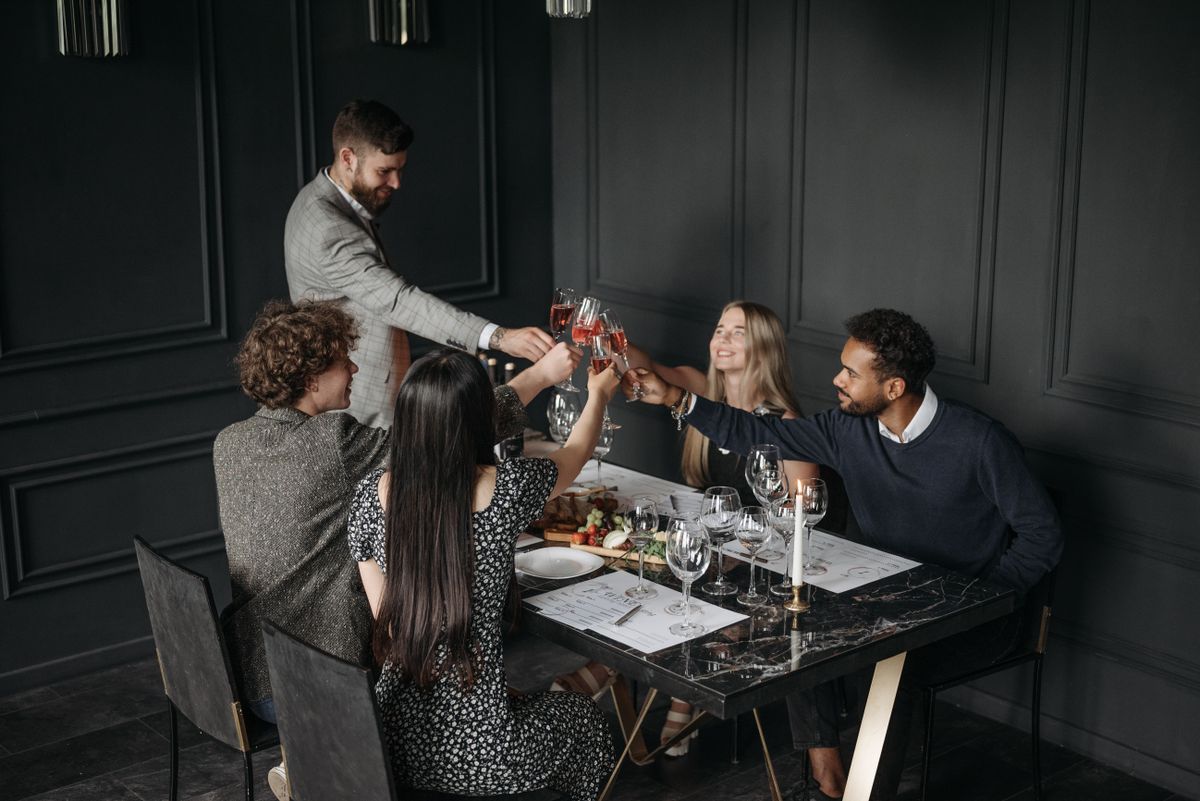 Group of colleagues toasting with glasses at a formal dinner table