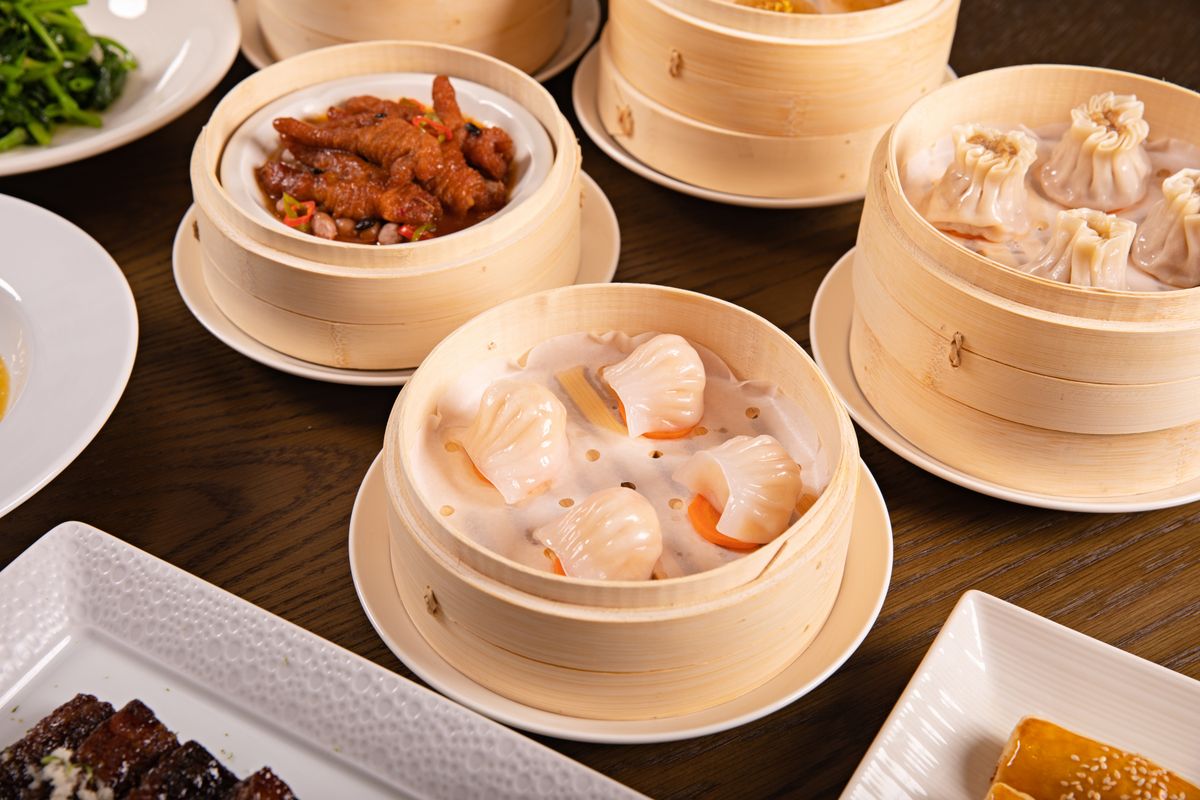 Dim sum served in traditional bamboo steamers, including shrimp dumplings and other small Cantonese plates