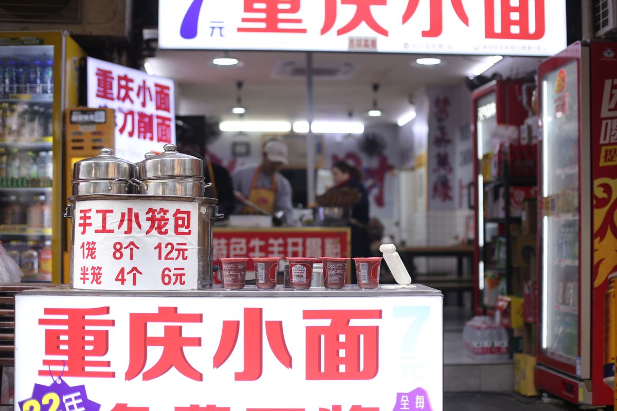 Chongqing noodle shop storefront with Chinese-only menu signage and prices in yuan
