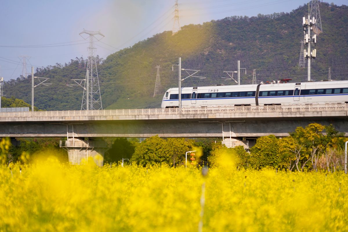 High-speed train crossing a bridge through rural fields along the Jinghu corridor between Beijing and Shanghai