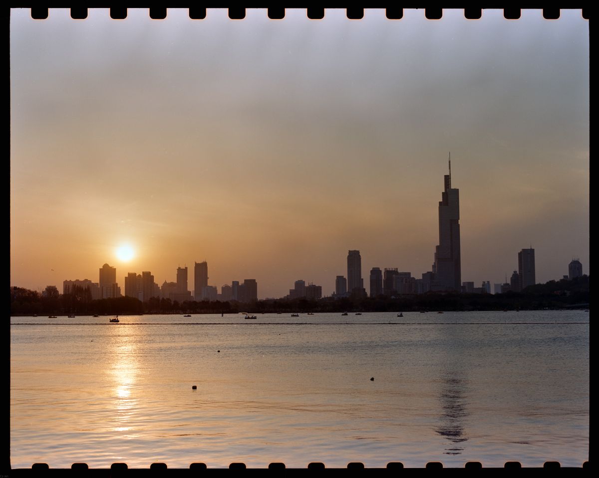 Nanjing skyline and Zifeng Tower reflected on Xuanwu Lake at sunset