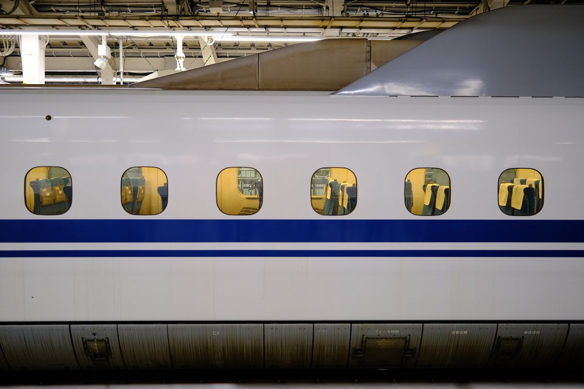 Close-up of a Chinese high-speed train's blue-striped exterior at a platform