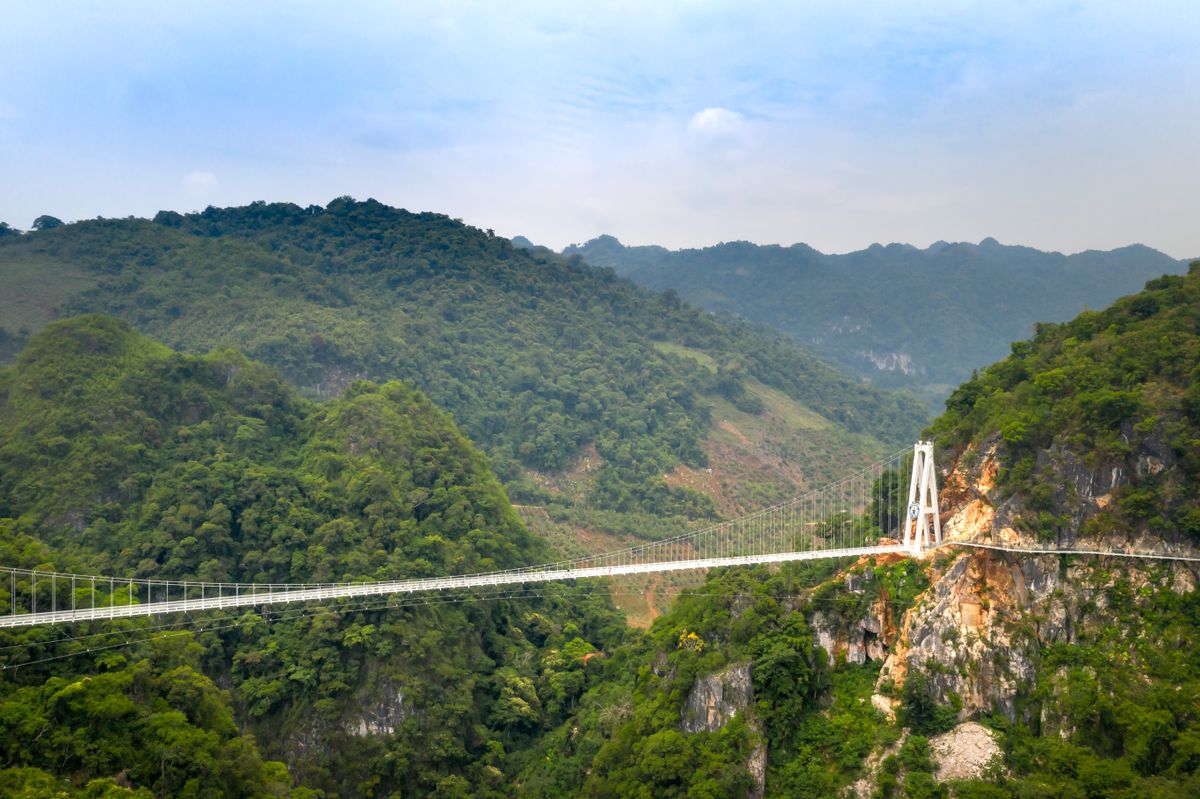 Glass skywalk bridge over a forested canyon near Zhangjiajie