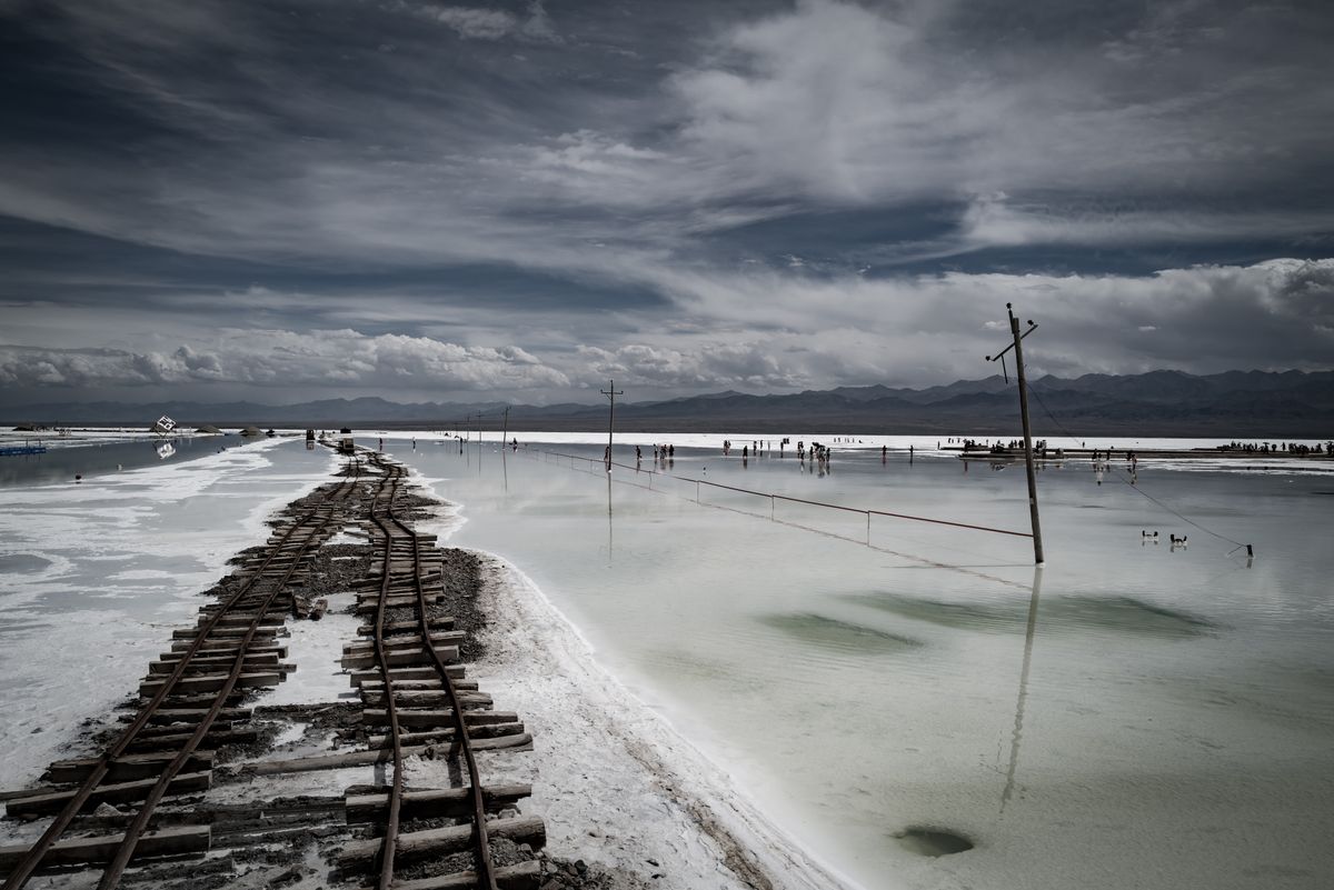 Salt flat railway tracks crossing a high-altitude Qinghai plateau lake