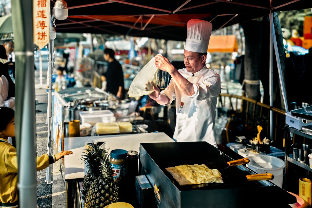Street food vendor preparing a snack at an outdoor stall in Shenzhen