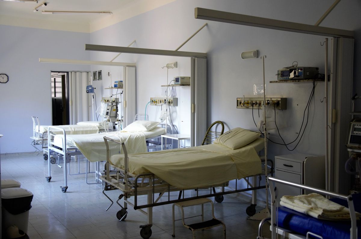Sala de hospital vacía con camas y equipo médico