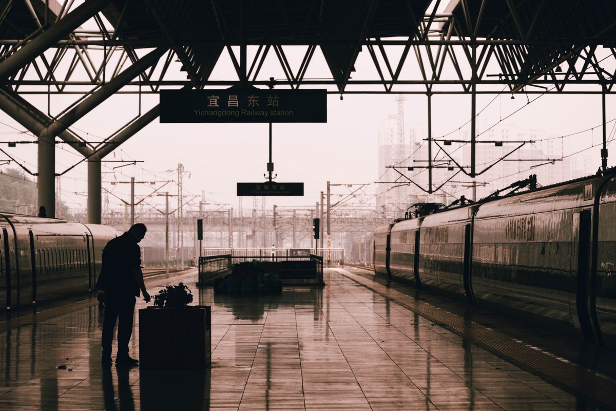 Passenger waiting on a platform under the Yichangdong Railway Station sign in China