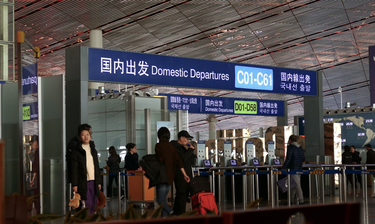 Sala de salidas nacionales del aeropuerto de Beijing Capital con señalización en chino, inglés, japonés y coreano