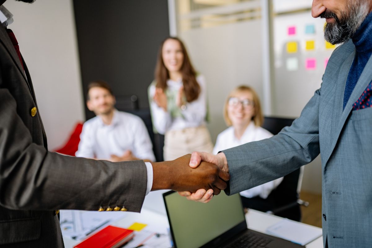 Two businesspeople shaking hands in an office meeting