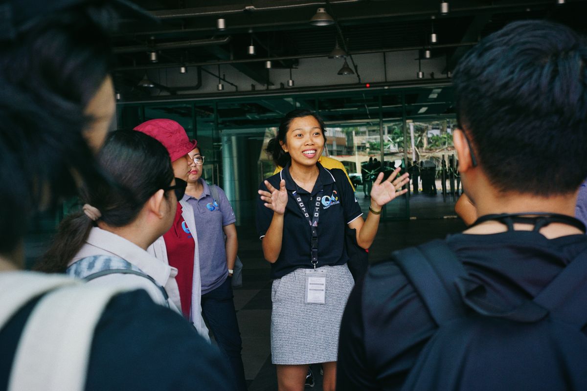 Tour guide gesturing to a group of travelers on a city street
