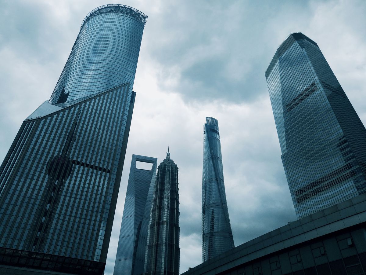 Shanghai's Lujiazui skyscrapers seen from street level against a cloudy sky