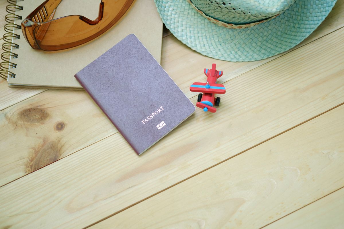 A Mexican passport next to travel essentials on a table
