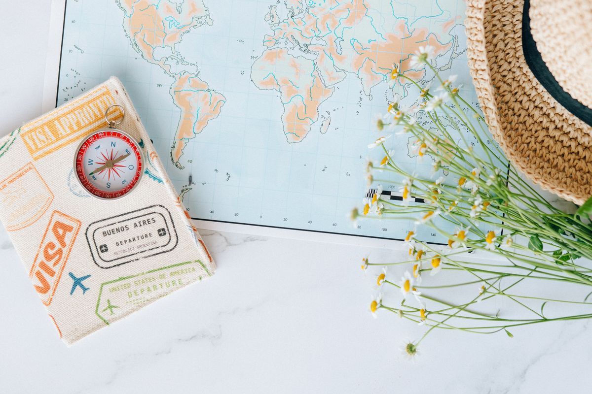 Passport and visa documents with a compass and travel map, representing the single vs multiple entry decision