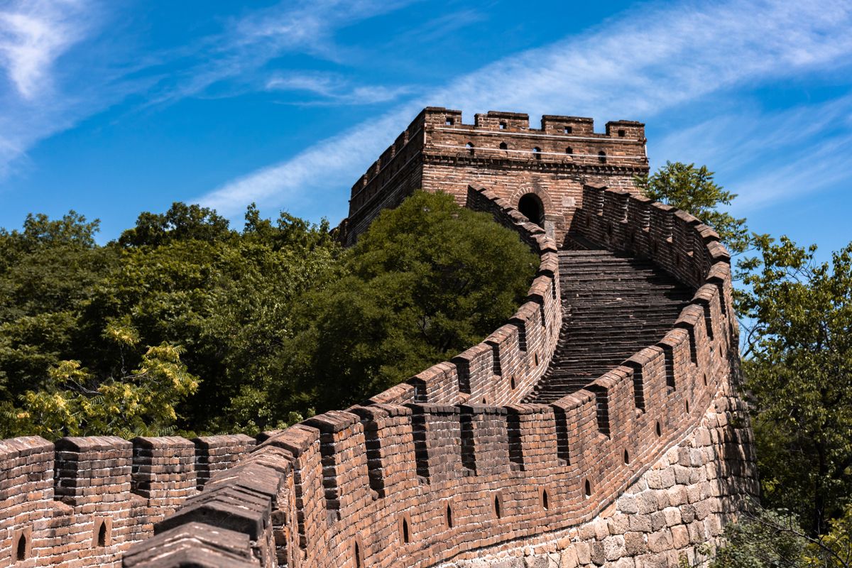 A restored watchtower and wall path on the Great Wall of China near Beijing under a clear blue sky