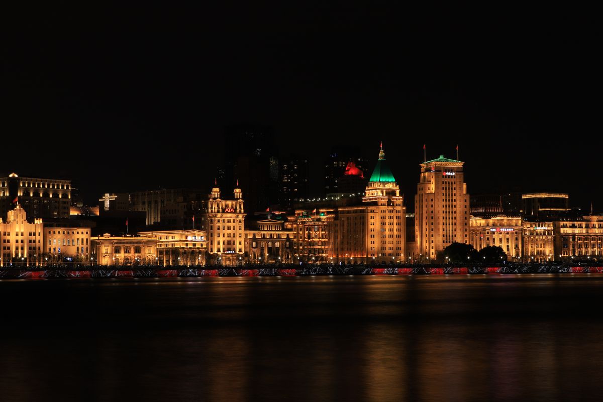 Shanghai's Bund waterfront skyline lit up at night, seen across the Huangpu River