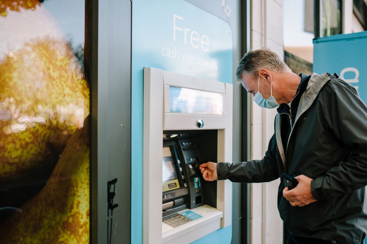 A traveler using a bank ATM on the street