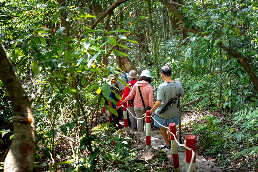 A small group of travelers walking a trail with their guide