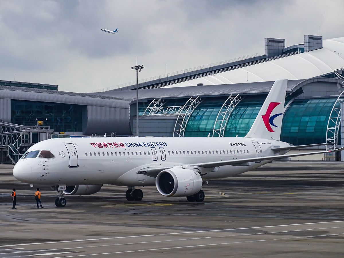 A China Eastern aircraft on the runway beside a modern terminal