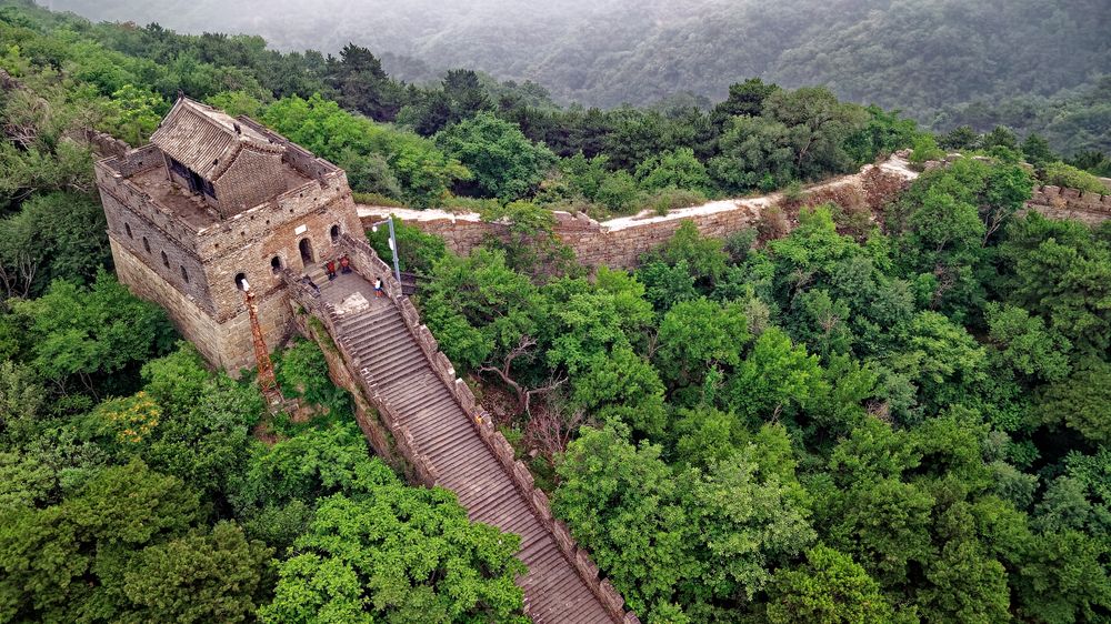 The Great Wall of China winding across green hills