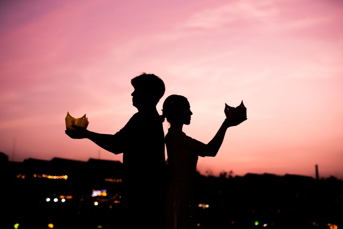 A couple holding lanterns at sunset