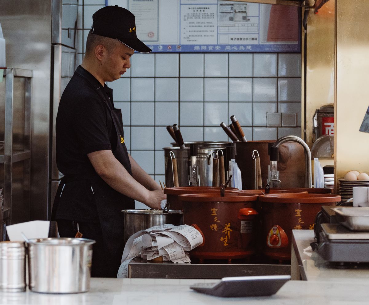 Cook working in a Chinese restaurant kitchen